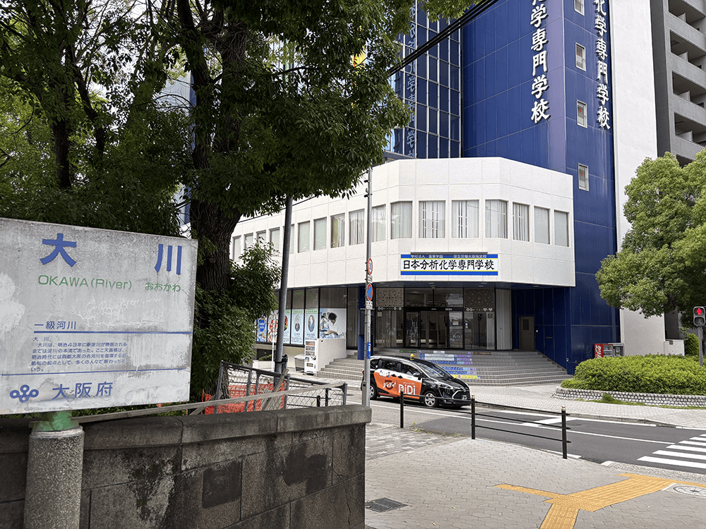 天満橋を渡り切ったらすぐに左折。「日本分析化学専門学校」が目印です。